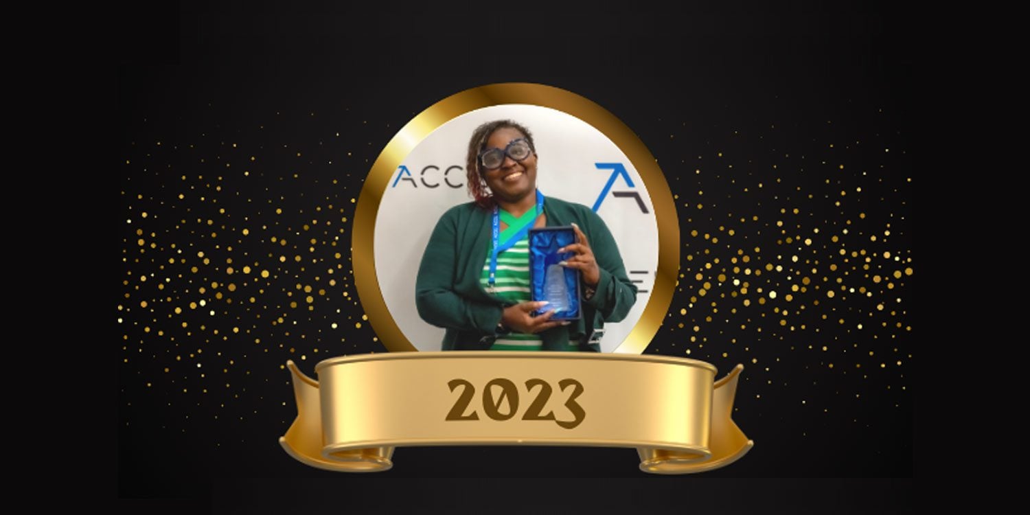 Adult holding a blue award, framed by a gold circle and ribbon with "2023".